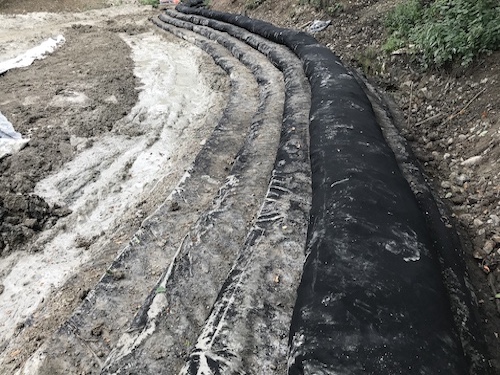 Image of several geotextile tubes layered to a dam